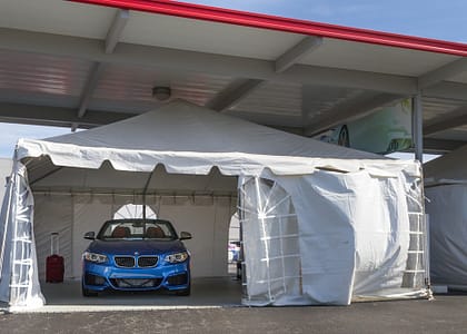 Blue BMW parked inside the white tent